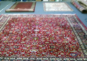 Inspection of a fine Oriental rug before cleaning